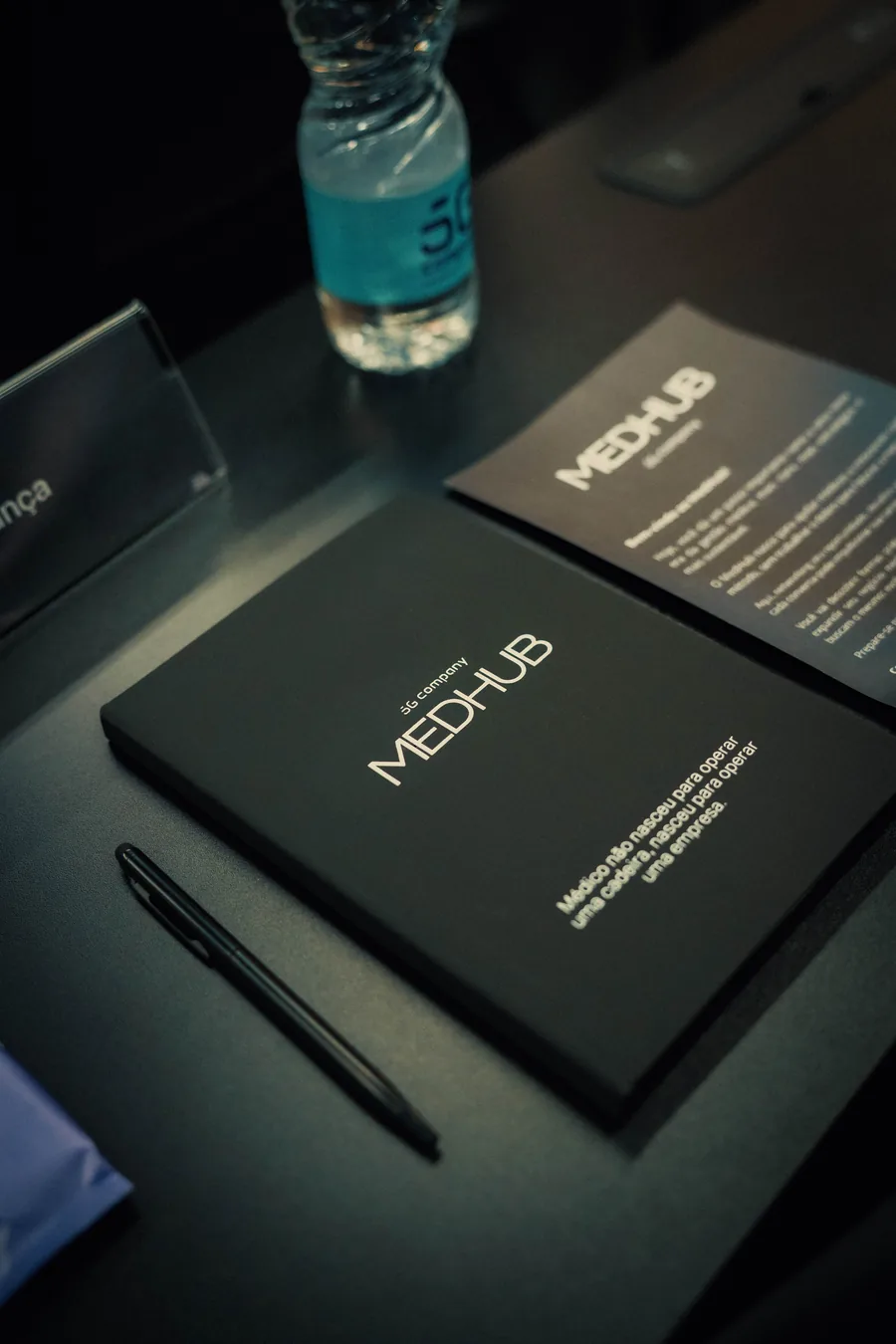 Caderno e caneta MedHub sobre a mesa de reunião