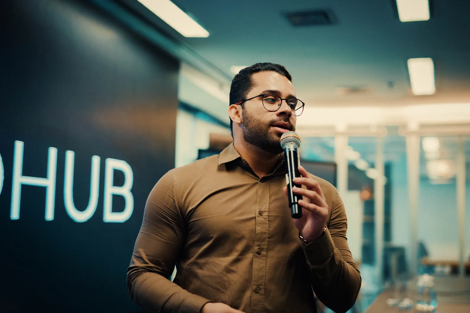 Membro apresentando ao microfone em frente ao painel MedHub
